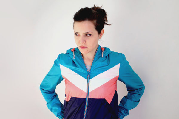 Portrait of a woman in a colorful jacket with hands in her pockets